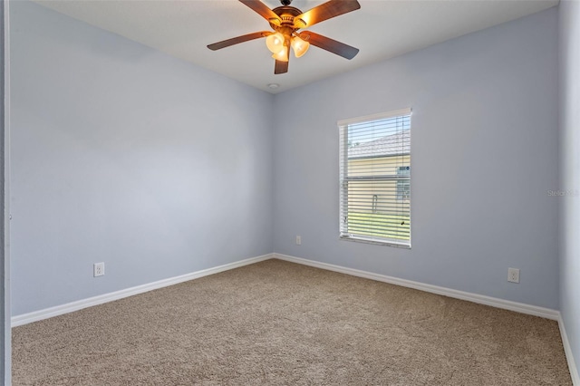 carpeted empty room featuring baseboards and a ceiling fan
