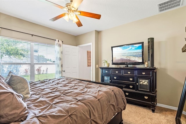 bedroom with light carpet, baseboards, and a ceiling fan