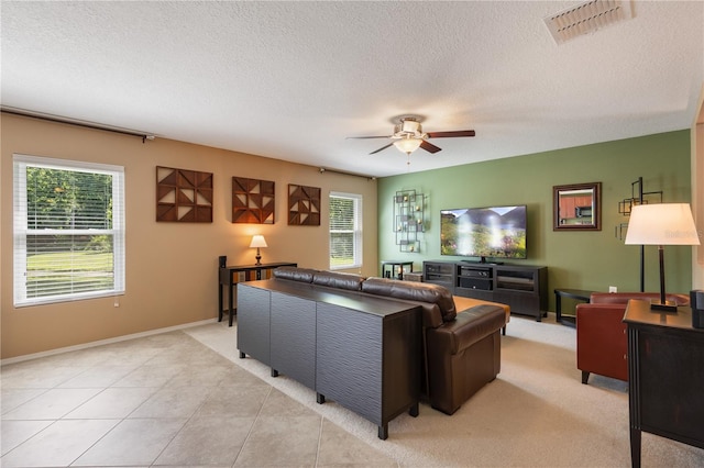 living area featuring a ceiling fan, a textured ceiling, and baseboards