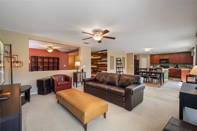 living area with a ceiling fan and light colored carpet