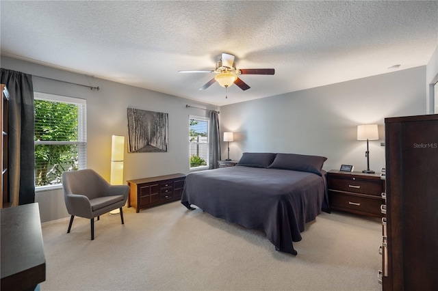 bedroom with light carpet, a ceiling fan, a textured ceiling, and freestanding refrigerator