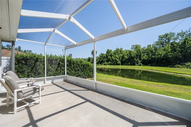 sunroom featuring a water view and view of scattered trees