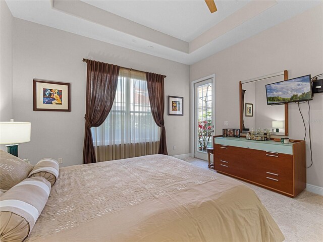 8333 Via Verona, Orlando, FL 32836 - bedroom featuring light colored carpet, baseboards, access to exterior, and a tray ceiling