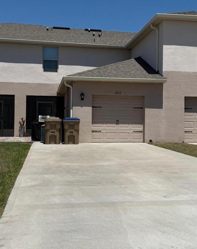 view of front facade featuring concrete driveway, stucco siding, and a garage