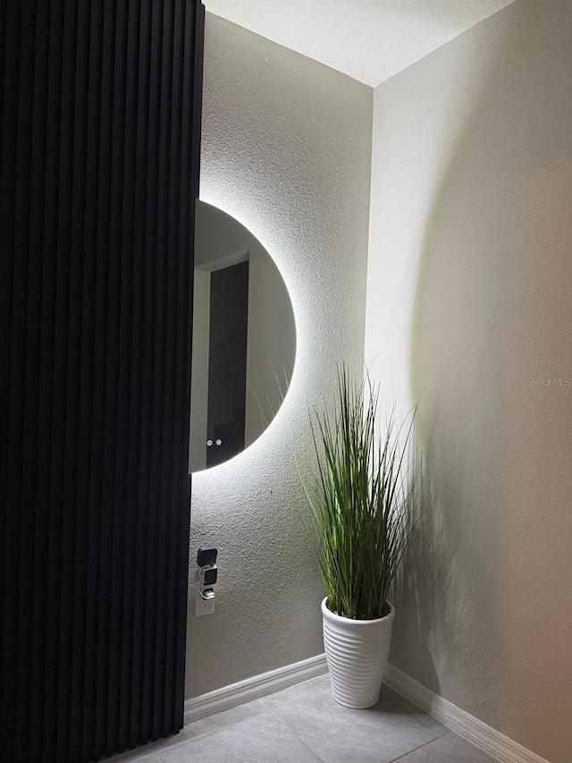 detailed view of baseboards and a textured wall