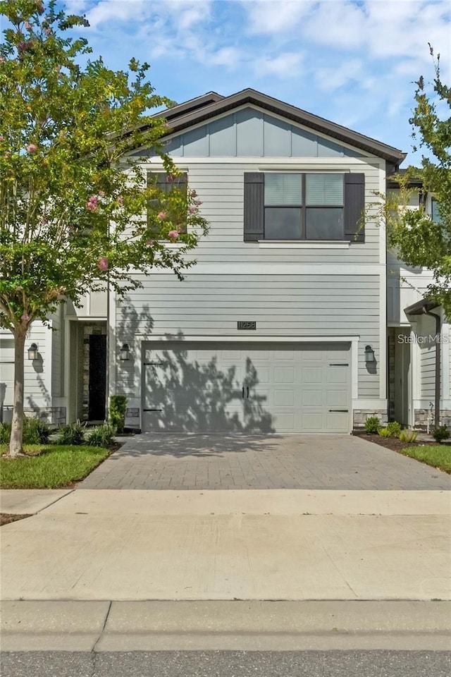 11258 Whistling Pine Way, Orlando, FL 32832 - traditional home with an attached garage, driveway, and board and batten siding