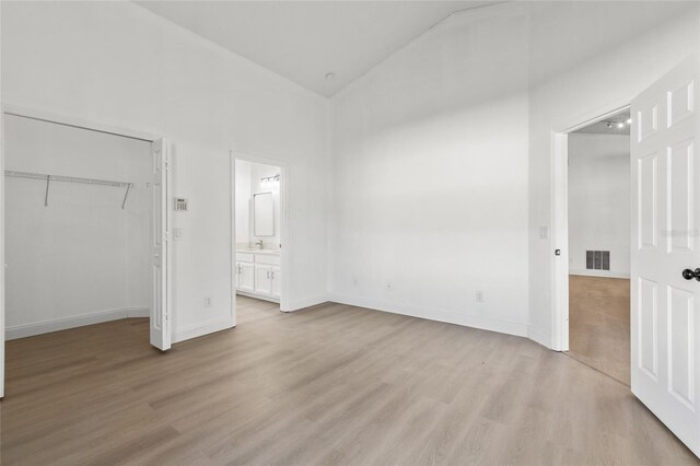 3078 Mandolin Dr, Kissimmee, FL 34744 - unfurnished bedroom featuring light wood-style flooring, high vaulted ceiling, a closet, connected bathroom, and baseboards