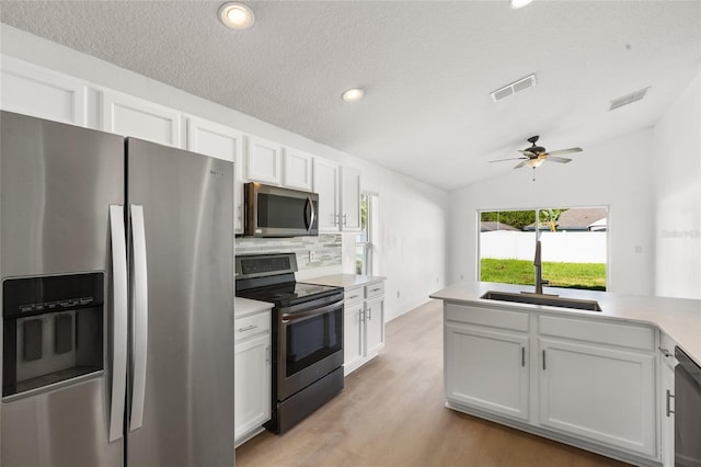 3078 Mandolin Dr, Kissimmee, FL 34744 - kitchen with stainless steel appliances, a sink, tasteful backsplash, vaulted ceiling, and white cabinets