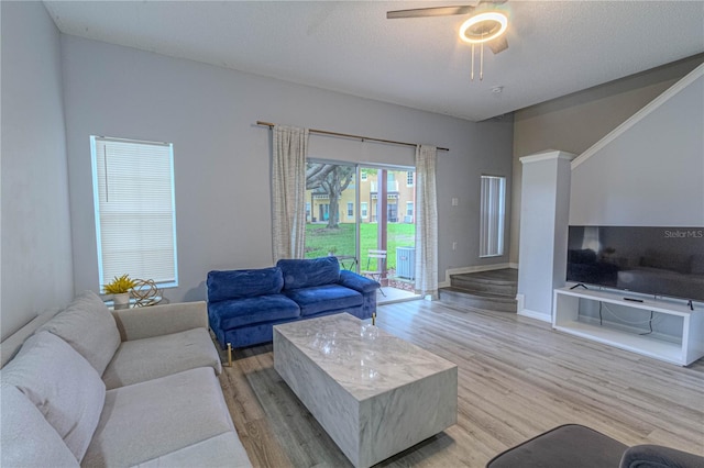 living area with light wood-style flooring, ceiling fan, and baseboards
