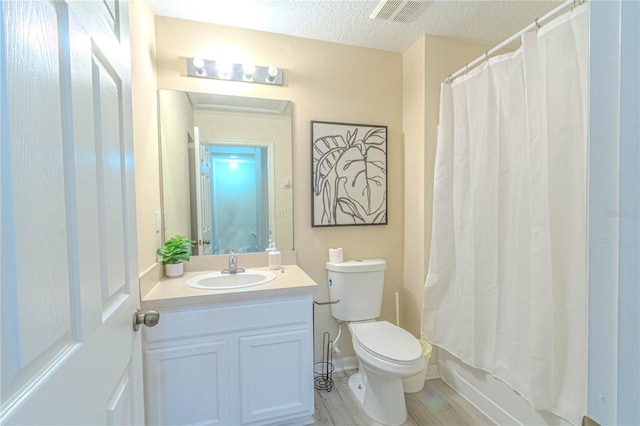 full bath with vanity, toilet, a textured ceiling, and wood finished floors