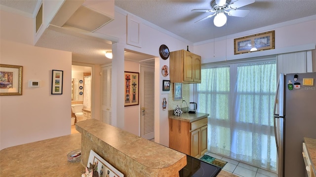 717 S Beach St Unit 205C, Daytona Beach, FL 32114 - kitchen featuring freestanding refrigerator, a ceiling fan, a textured ceiling, and light tile patterned floors