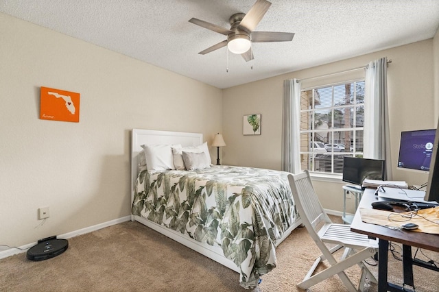 carpeted bedroom with baseboards, a textured ceiling, a desk, and ceiling fan