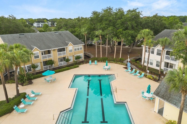 community pool with a patio and fence