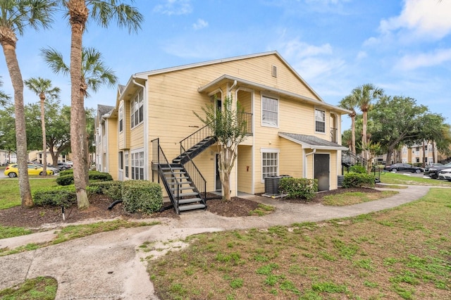 view of front of property with stairway and central AC