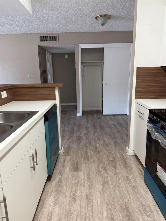 5540 Devonbriar Way Unit 103, Orlando, FL 32822 - kitchen featuring stove, dishwasher, light wood-style floors, light countertops, and a textured ceiling