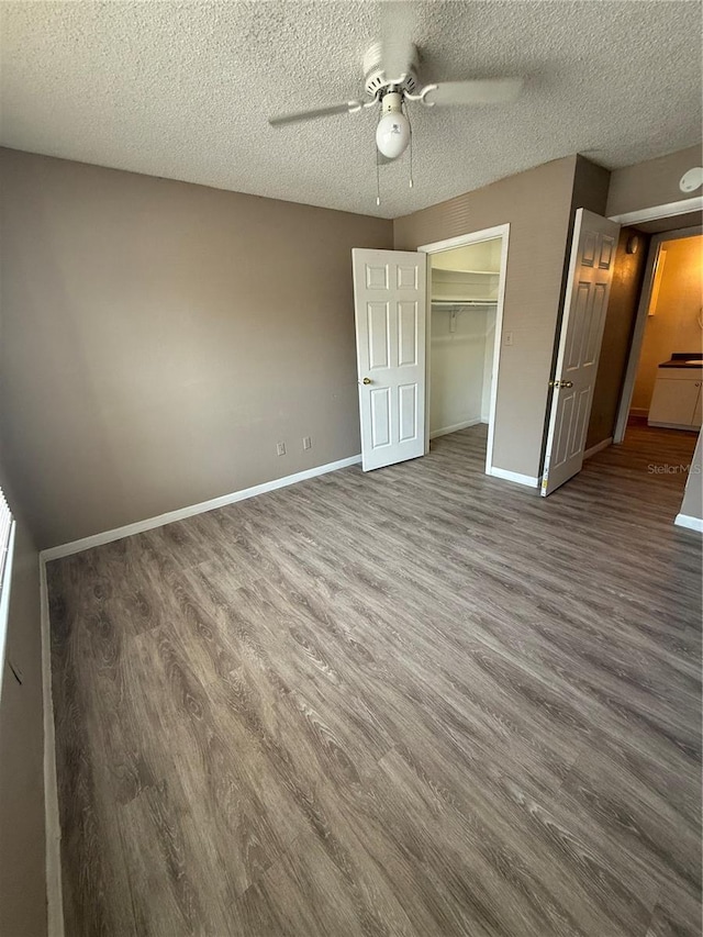 5540 Devonbriar Way Unit 103, Orlando, FL 32822 - unfurnished bedroom with wood finished floors, a textured ceiling, baseboards, a closet, and a ceiling fan