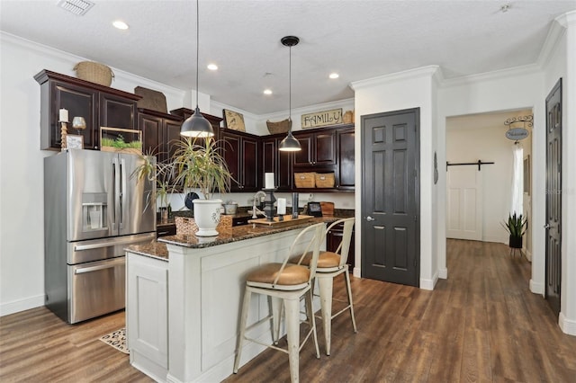 kitchen featuring stainless steel fridge with ice dispenser, dark wood-style flooring, dark brown cabinetry, an island with sink, and dark stone counters