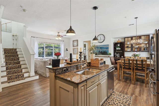 kitchen featuring a sink, stainless steel appliances, a ceiling fan, dark wood-type flooring, and a textured ceiling
