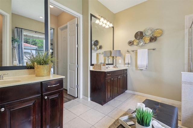 full bath with tile patterned flooring, two vanities, and baseboards