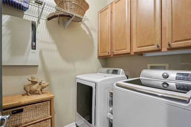 clothes washing area with washer and dryer and cabinet space