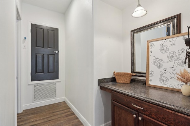 foyer with dark wood-style flooring and baseboards