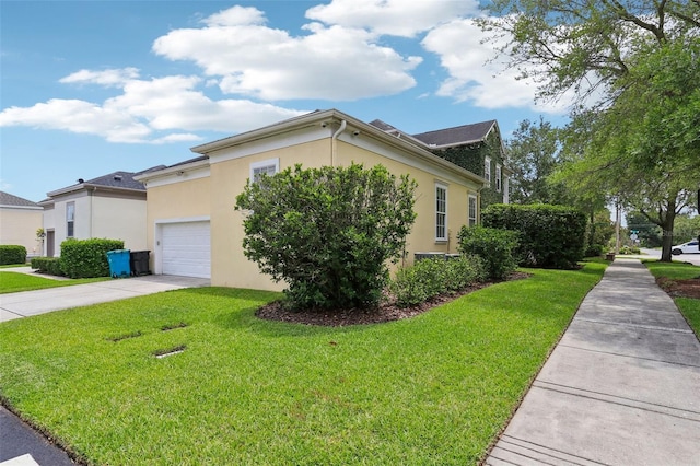 view of side of property featuring stucco siding, driveway, a lawn, and an attached garage