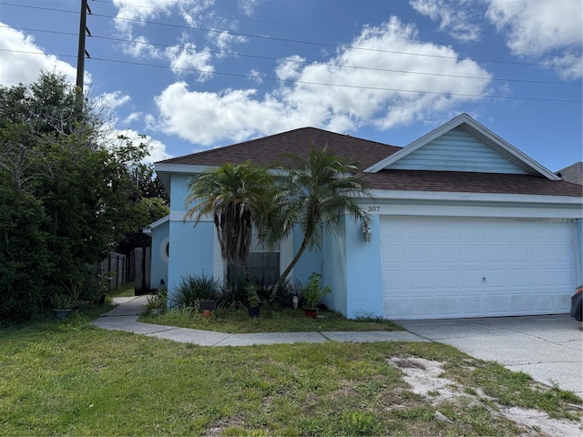 ranch-style home featuring driveway, an attached garage, a front yard, roof with shingles, and stucco siding