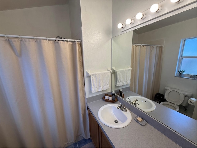 full bathroom with toilet and vanity