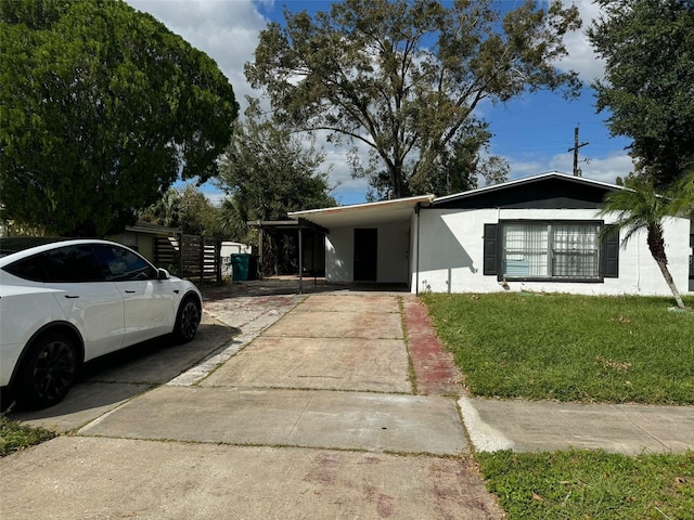 4061 Kirkland Blvd, Orlando, FL 32811 - view of front facade featuring concrete driveway, a carport, stucco siding, and a front lawn
