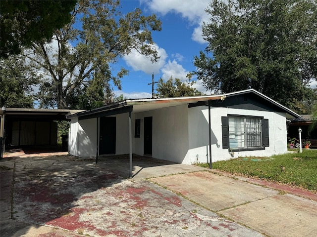 4061 Kirkland Blvd, Orlando, FL 32811 - view of front of home with driveway, an attached carport, stucco siding, and a front lawn