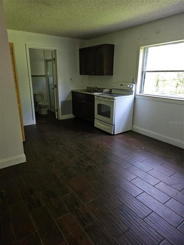 4061 Kirkland Blvd, Orlando, FL 32811 - kitchen with white electric range oven, a textured ceiling, dark wood-type flooring, a sink, and baseboards