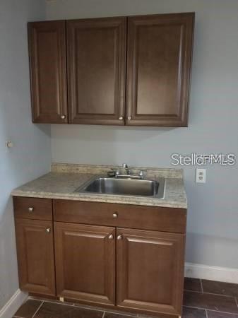 4061 Kirkland Blvd, Orlando, FL 32811 - kitchen with a sink, baseboards, and light countertops