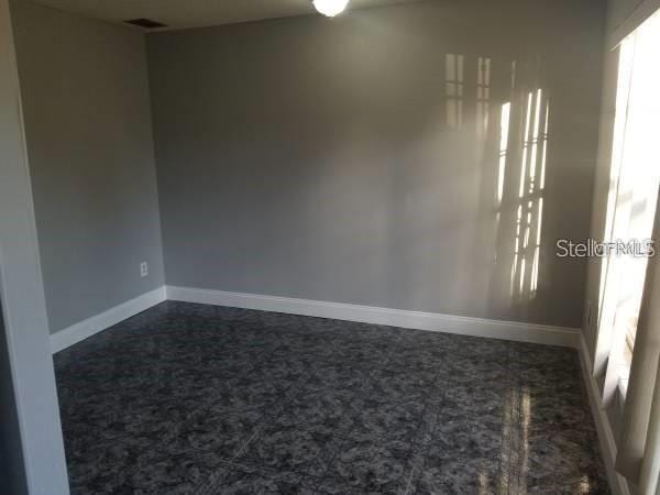4061 Kirkland Blvd, Orlando, FL 32811 - unfurnished room with dark colored carpet and baseboards