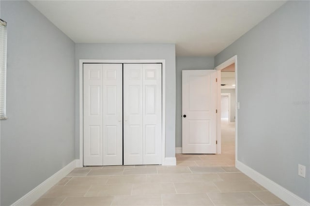 4651 Helena St NE, Saint Petersburg, FL 33703 - unfurnished bedroom featuring baseboards, a closet, and light tile patterned flooring