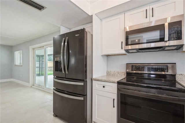 4651 Helena St NE, Saint Petersburg, FL 33703 - kitchen with stainless steel appliances, white cabinets, light stone countertops, and baseboards