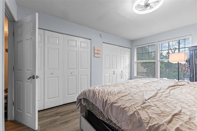 758 E Michigan St Unit 208, Orlando, FL 32806 - bedroom featuring wood finished floors, two closets, and a textured ceiling