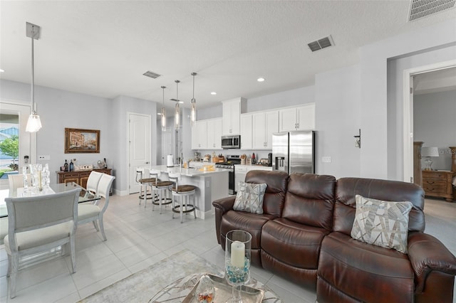 living area featuring light tile patterned floors, recessed lighting, and a textured ceiling
