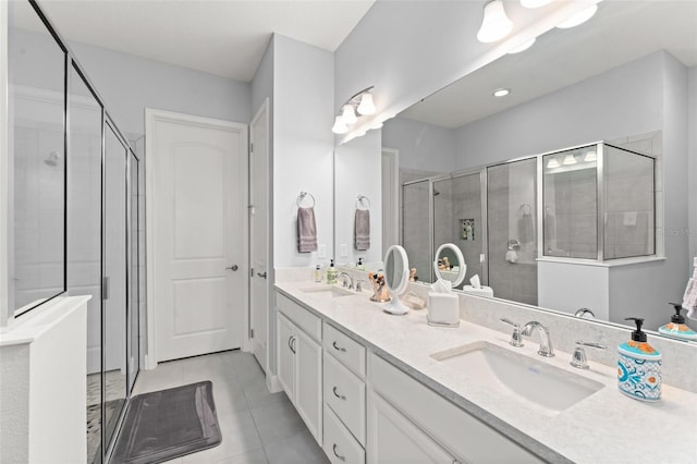 full bathroom featuring a shower stall, tile patterned flooring, and double vanity