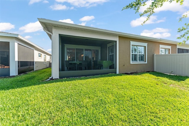 rear view of house featuring a sunroom and stucco siding