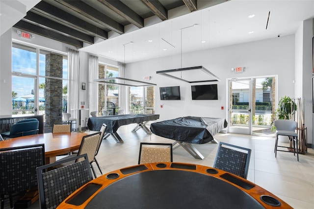 community lobby with beam ceiling, a towering ceiling, and recessed lighting