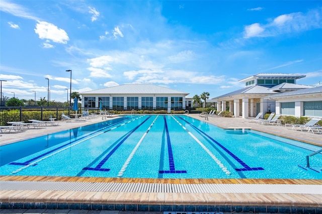community pool with fence and a patio