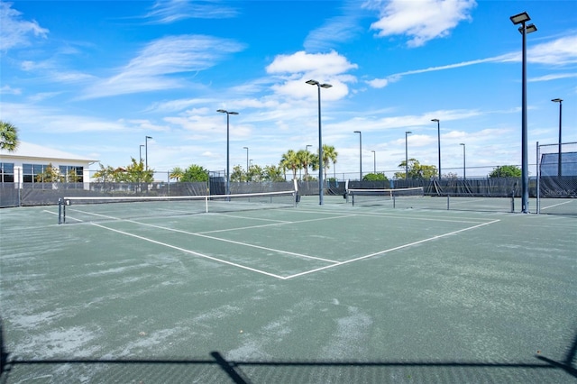 view of tennis court featuring fence and community basketball court