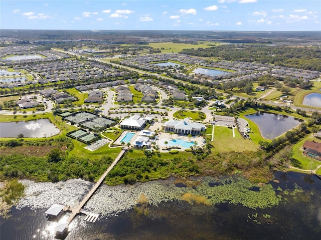view of property location featuring a large body of water, a pool area, and nearby suburban area