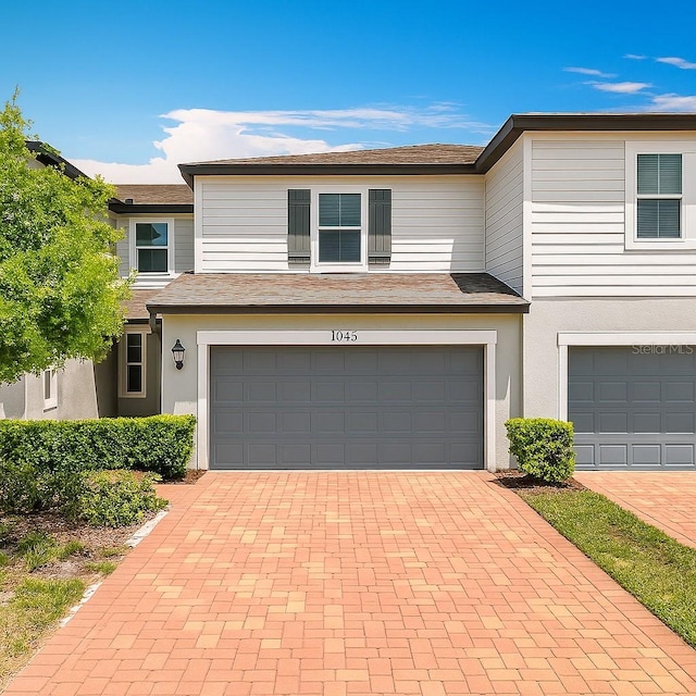 1045 Desert Candle Dr, Ocoee, FL 34761 - view of front of property featuring an attached garage, decorative driveway, and stucco siding