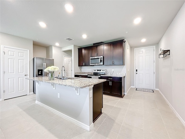 1045 Desert Candle Dr, Ocoee, FL 34761 - kitchen featuring appliances with stainless steel finishes, a sink, baseboards, recessed lighting, and light stone counters