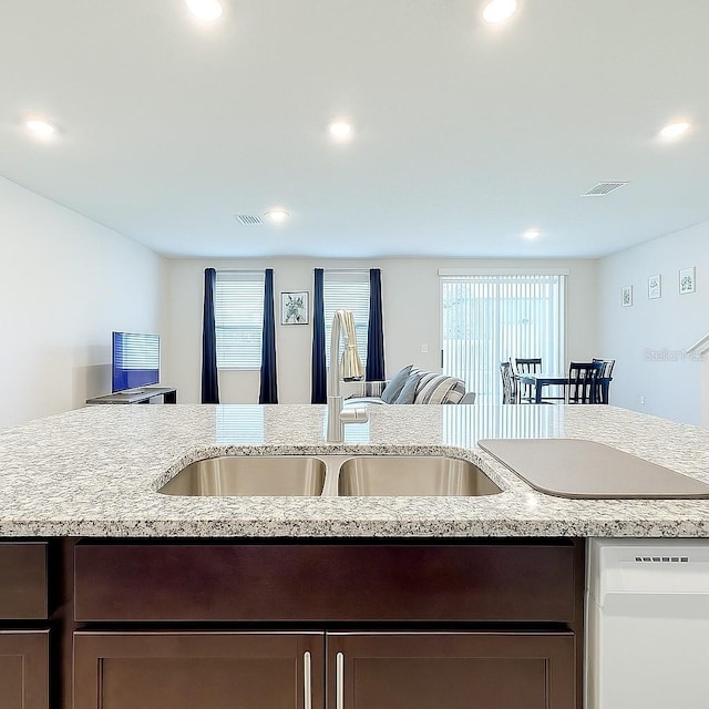 1045 Desert Candle Dr, Ocoee, FL 34761 - kitchen with dishwasher, healthy amount of natural light, dark brown cabinets, a sink, and recessed lighting