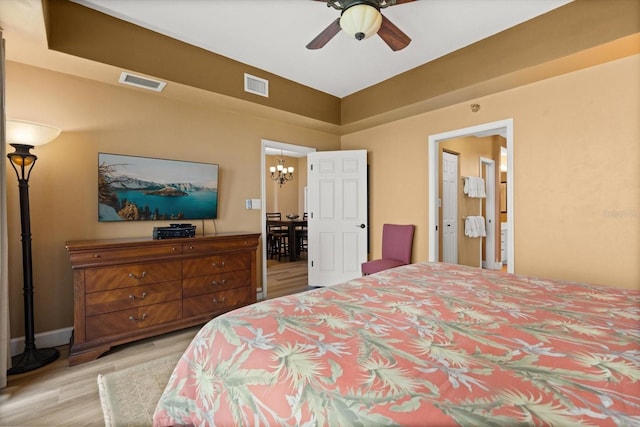 bedroom with light wood finished floors, a chandelier, baseboards, and a ceiling fan