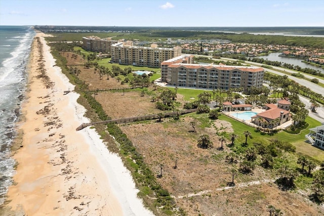 bird's eye view of apartment complex, extended coastline, and a pool