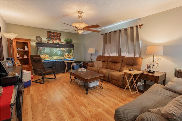3216 White Blossom Ln, Clermont, FL 34711 - living room featuring light wood finished floors, ceiling fan, and a textured ceiling