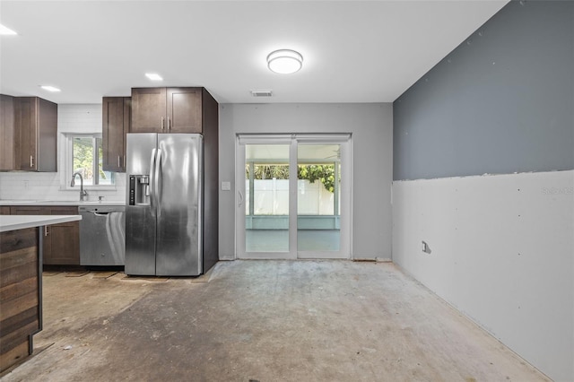 2302 16th St W, Palmetto, FL 34221 - kitchen with stainless steel appliances, concrete flooring, dark brown cabinets, light countertops, and plenty of natural light